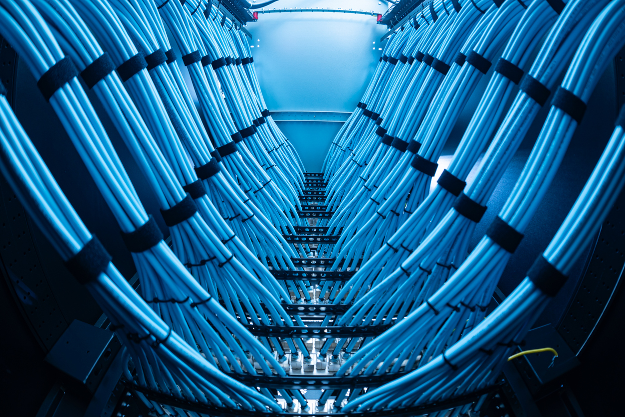 A captivating view of a modern data center showcasing a complex arrangement of blue cables. This interior captures the essence of high-tech communication infrastructure.